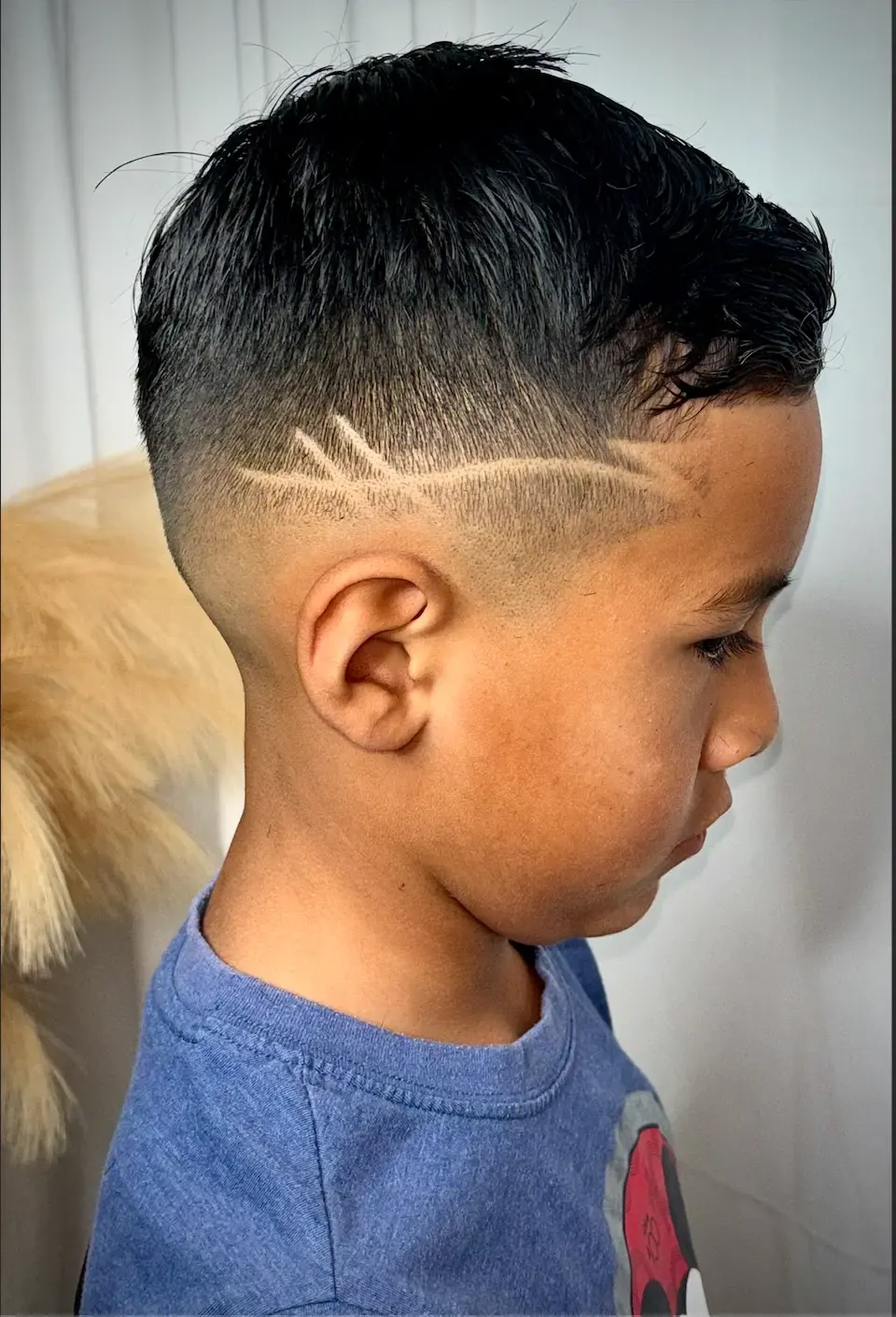 Side profile of a young boy with a skin fade and a zigzag line design